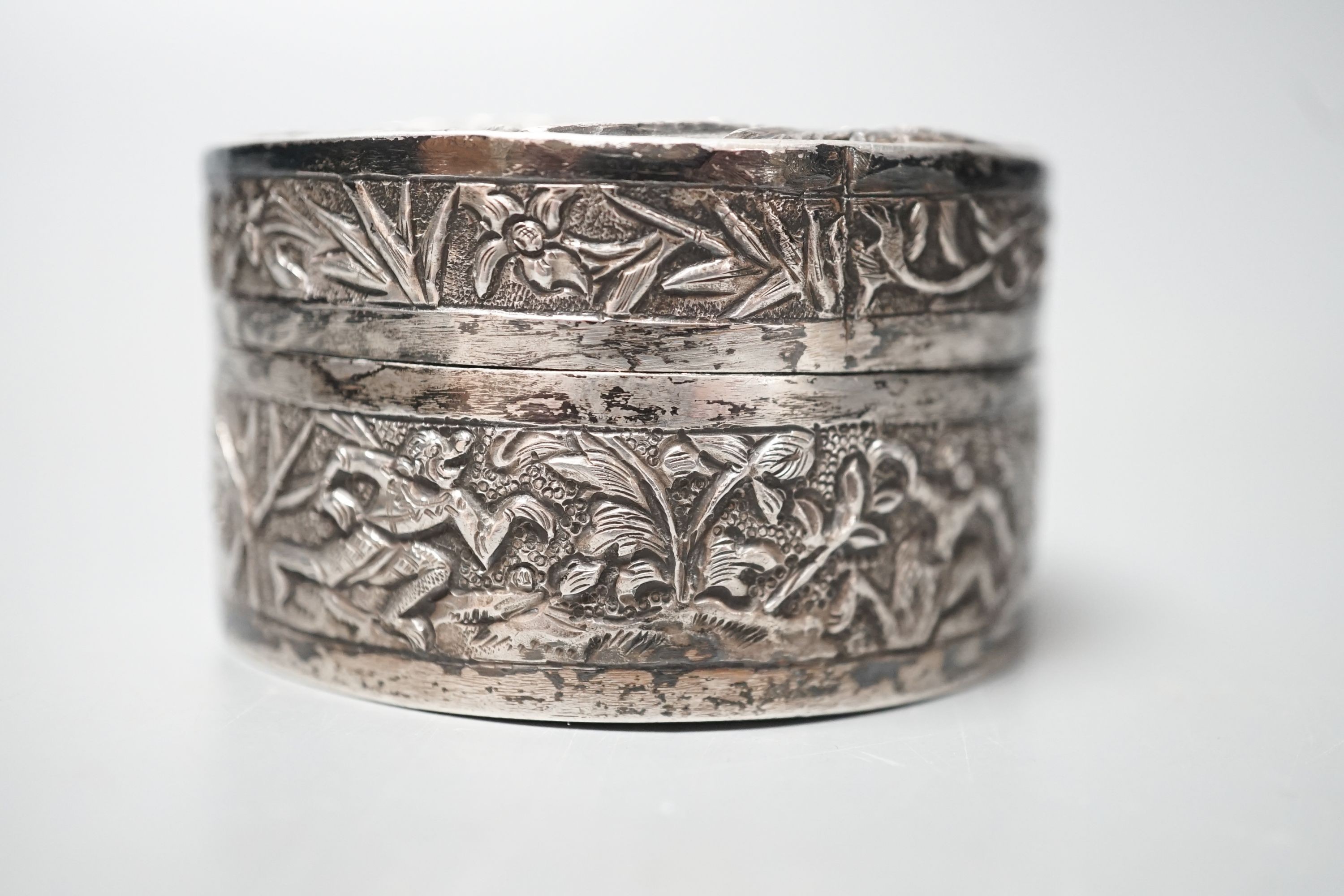 A Chinese embossed white metal circular box and cover, late 19th century, diameter 61mm.